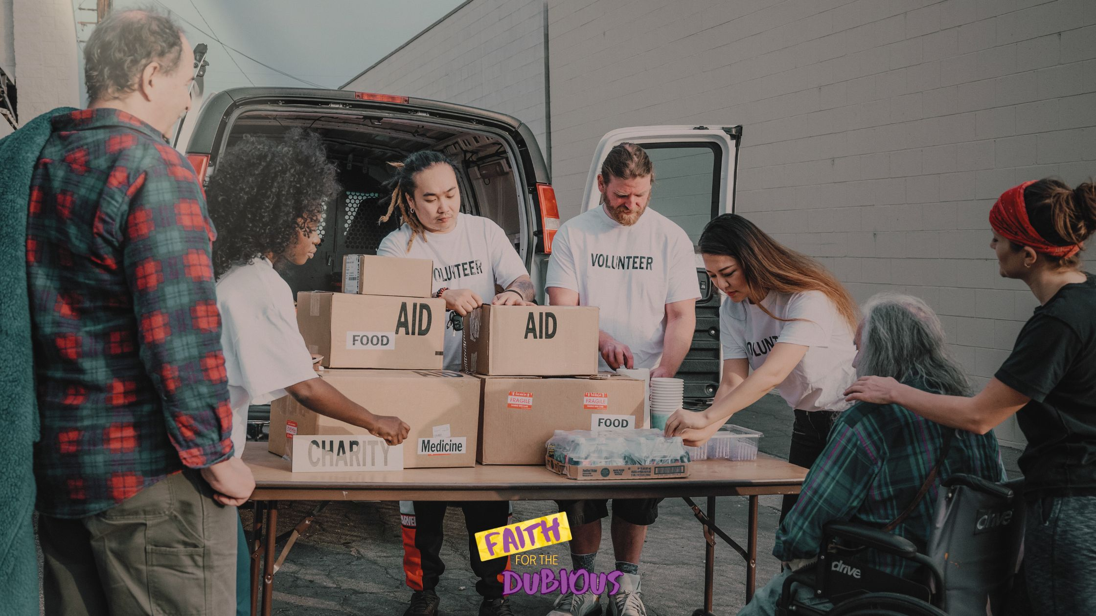 People handing out boxes of food, led by a food drive volunteer.