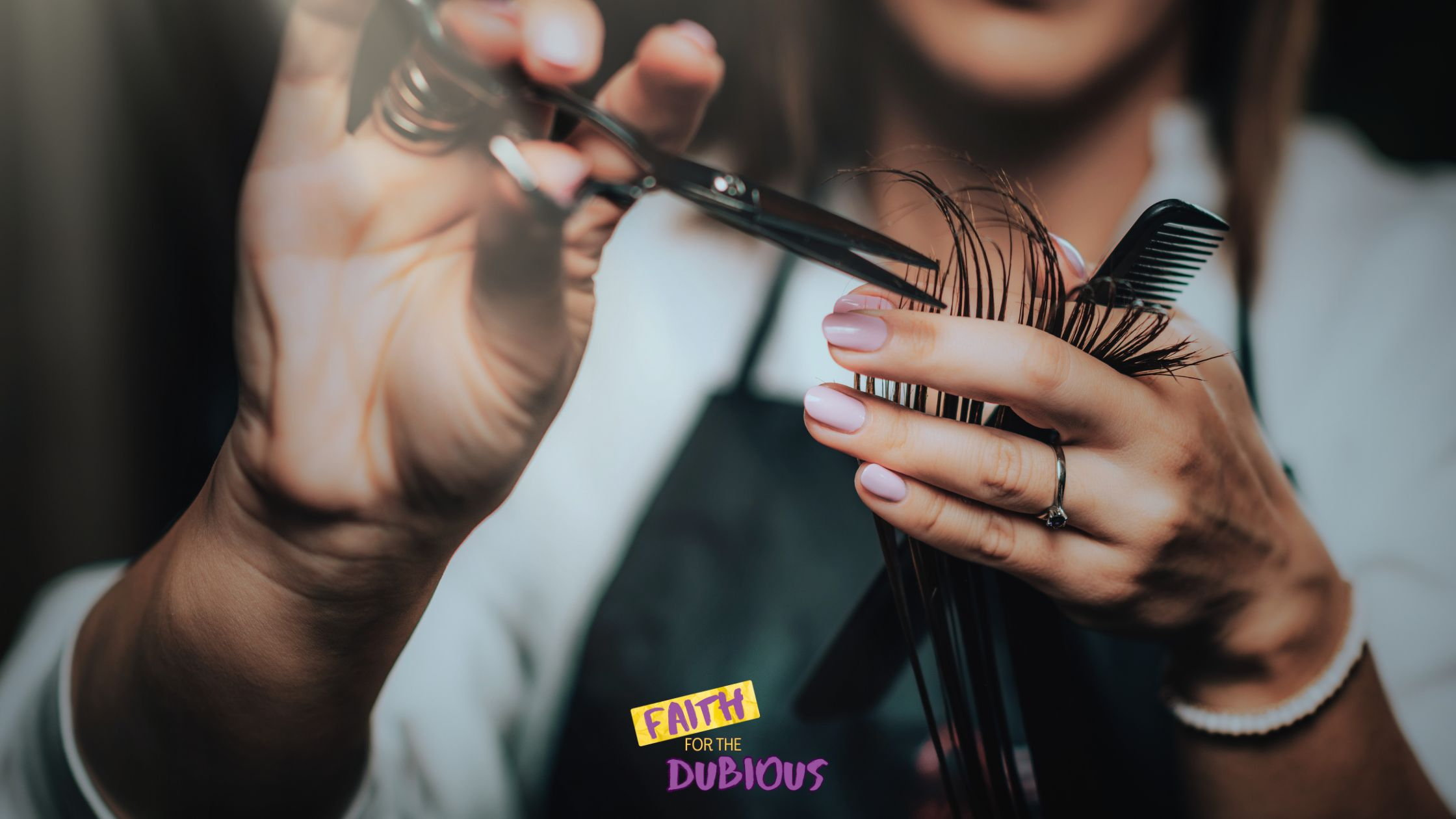 Close-up of a woman cutting hair at a free haircut event.